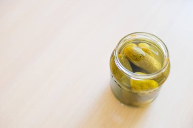 Masanın üzerinde açık kavanozda salatalık turşusu. Boşluğu kopyala