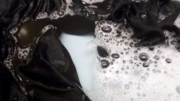 Laver la chose sombre dans l'eau avec de la mousse et des bulles éclater . — Video