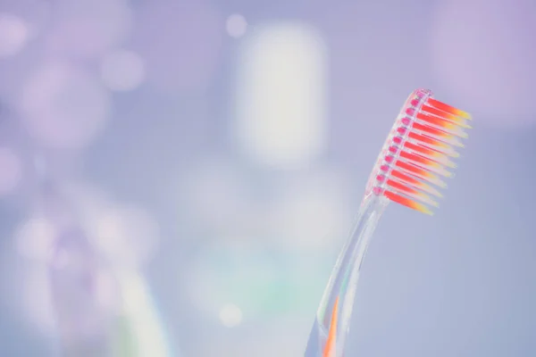 Cepillo Dientes Plástico Naranja Sobre Fondo Púrpura Con Burbujas —  Fotos de Stock