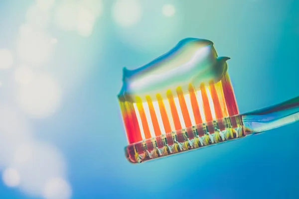 Orange Plastic Toothbrush Toothpaste Blue Background Side View Art Bokeh — Stock Photo, Image