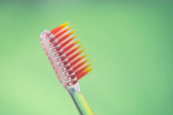 Cepillo Dientes Plástico Naranja Sobre Fondo Verde —  Fotos de Stock