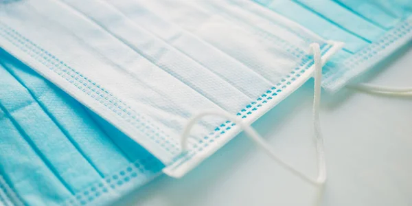 Blue medical face masks on the white table. Side view