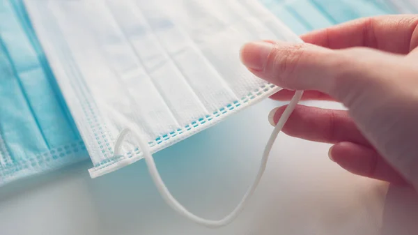 Mano Femenina Toma Una Máscara Médica Mesa Primer Plano Vista —  Fotos de Stock