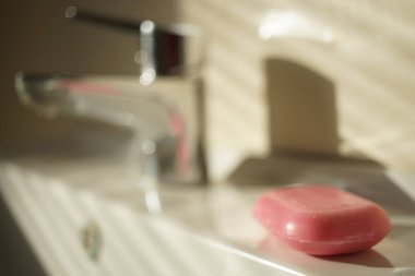 Banyodaki lavaboda pembe bir kalıp sabun. Yan görünüm kapat
