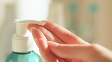 Plastik şişede bir kadın parmağı ve jel yakın plan.