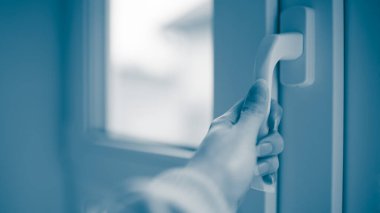 Kadın eli pencereyi açar, yan görünüm yakın plan, mavi ton