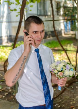 Bir buket çiçek mobil bir chat yapan adamla