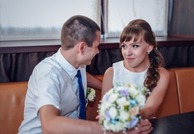 Windows tarafından köşe standında gülümseyen yeni evliler oturmak