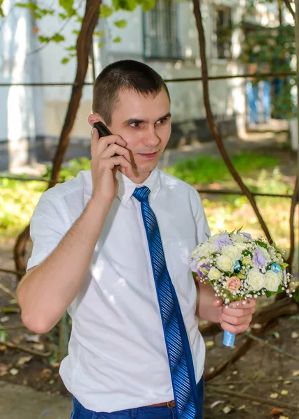 Bir buket çiçek mobil bir chat yapan adamla