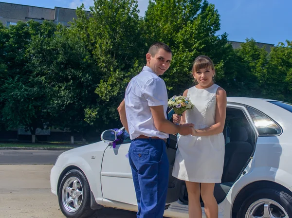 Giovane sposa e sposo alla macchina nuziale — Foto Stock