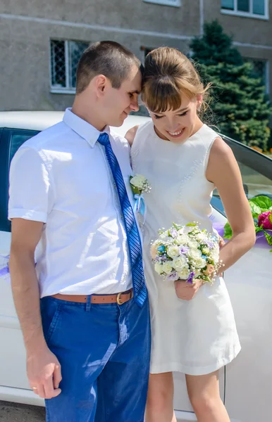 Pasangan pengantin muda berdiri di dekat mobil — Stok Foto