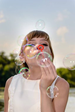 Genç ve güzel yeni evli gelin sabun köpüğü üfleme