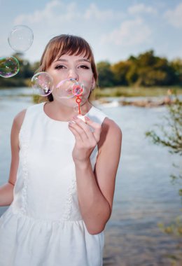 Genç ve güzel yeni evli gelin sabun köpüğü üfleme