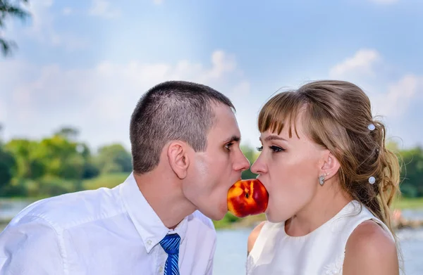 Romantic young newlywed couple sharing a fruit — Stock Photo, Image