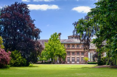 Tarihi konağın manzarası ve yazın manzaralı resmi bahçeler.