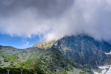 Yüksek Tatra Dağları bulutlar güneşli gün ile Lomnicky Stit kapalı.