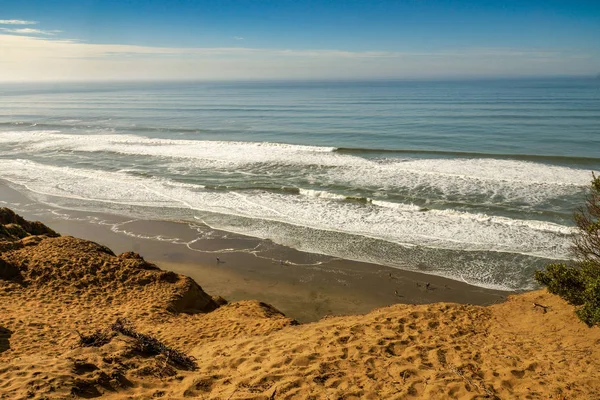 Pasifik Okyanusu dalgaları CA kumlu bir uçurumun üzerinden bakarak