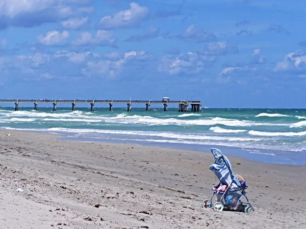 Issız plajda bir bebek arabası kaldı.
