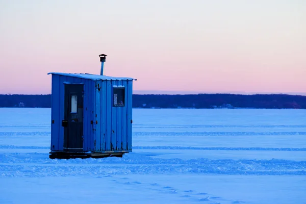 İzole buz balıkçılık kulübe batımında donmuş bir gölün üzerinde