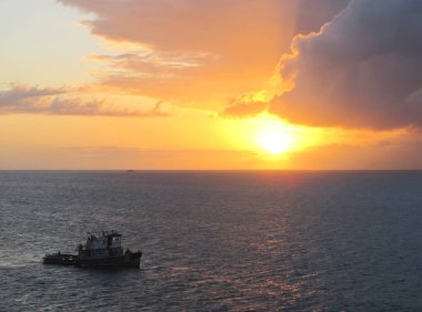 Gün batımında okyanusta balıkçı teknesi