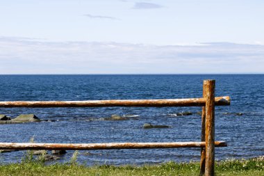 Koyu mavi denizin ve açık mavi gökyüzünün önünde bir levrek çiti..
