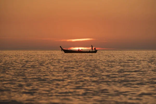 Pescadores navegando en el mar al atardecer — Foto de Stock