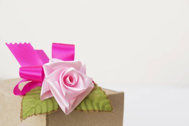 Bir kutu üstünde belgili tanımlık tepe yapay pembe Gül yay ile