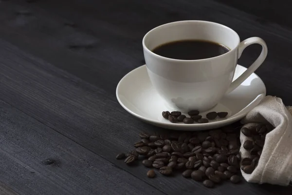 Una taza de café y granos de café — Foto de Stock