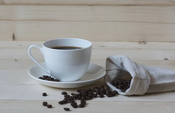 Una taza de café negro y granos de café — Foto de Stock