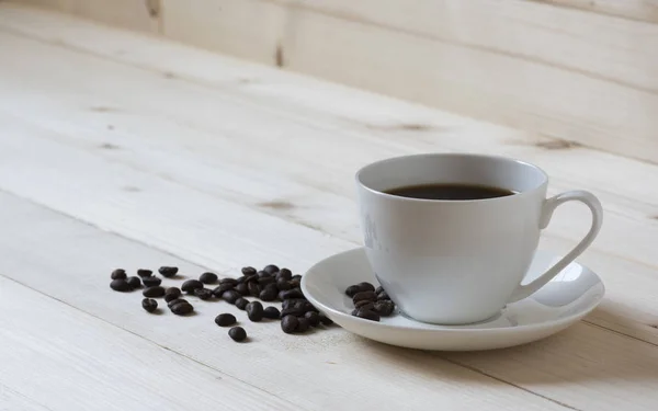 Una taza de café y granos de café — Foto de Stock