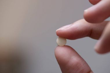 Bir tablet tıp tutan parmak