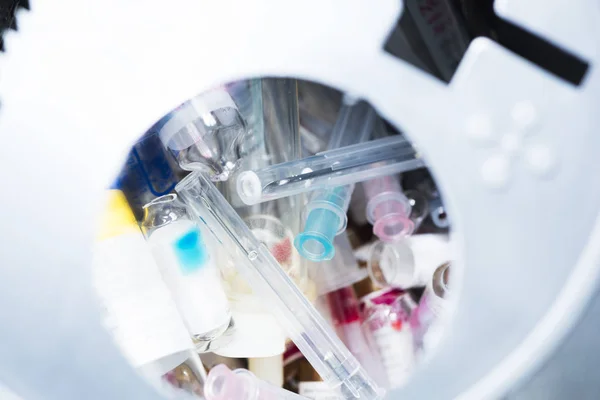 Используемые иглы, стакан инъекционного препарата в контейнере — стоковое фото