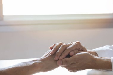 Doktor hasta elini tutarak