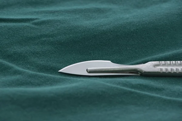 Vue rapprochée d'un couteau chirurgical sur une gaine verte — Photo