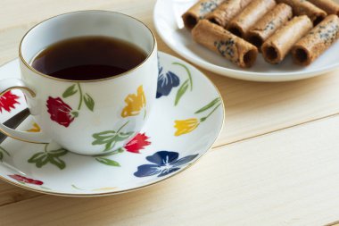 Bir fincan çay ve bir tabak Hindistan cevizi rulo