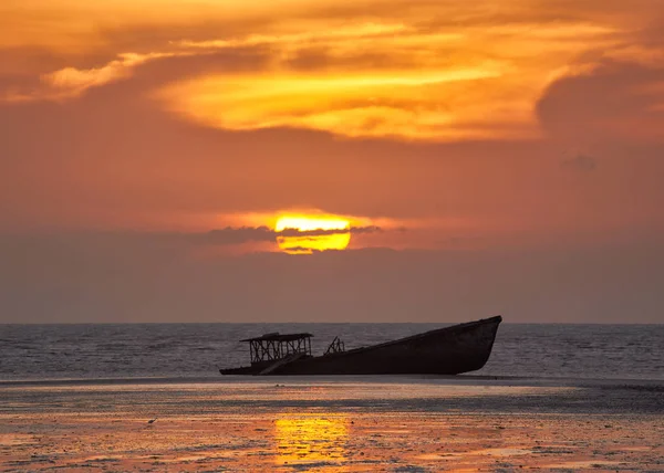 Scene of sink boat, beautiful sunrise and orange sky