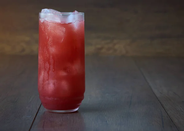 Un vaso de sabroso jugo de fresa fría con hielo sobre la mesa . — Foto de Stock