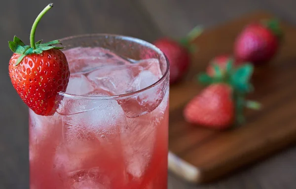 Un vaso de sabroso jugo de fresa fría con hielo sobre la mesa . —  Fotos de Stock