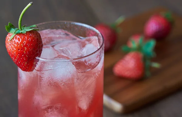 Um copo de saboroso suco de morango frio com gelo na mesa . — Fotografia de Stock