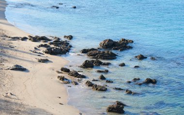 Sahildeki kayaların yüksek açılı görüntüsü. Güneşli bir günde Güzel mavi deniz