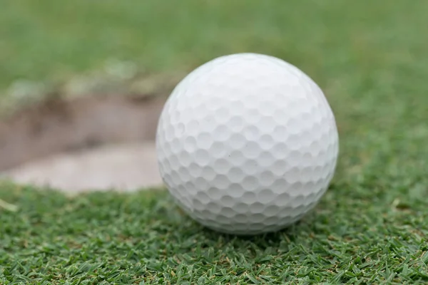 Golf ball on lip of cup — Stok fotoğraf