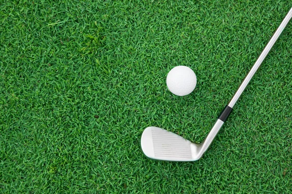demir golf kulübü ve top yeşil çimenlerin üzerinde