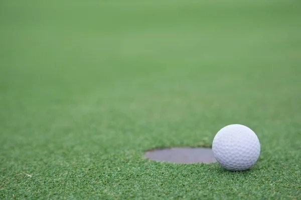 Golf ball on lip of cup — Stok fotoğraf