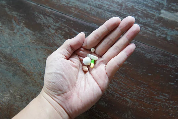 Homme avec des médicaments sur la main — Photo