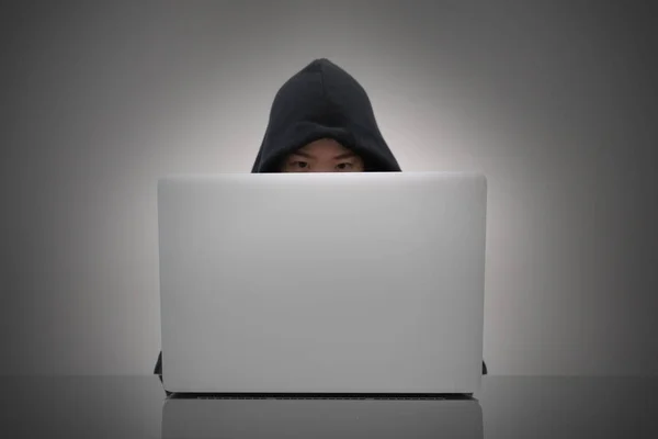 ノート パソコンから情報をハッキングのフードを着ている女性 — ストック写真