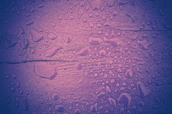 Gotas de chuva em madeira violeta filtrada — Fotografia de Stock
