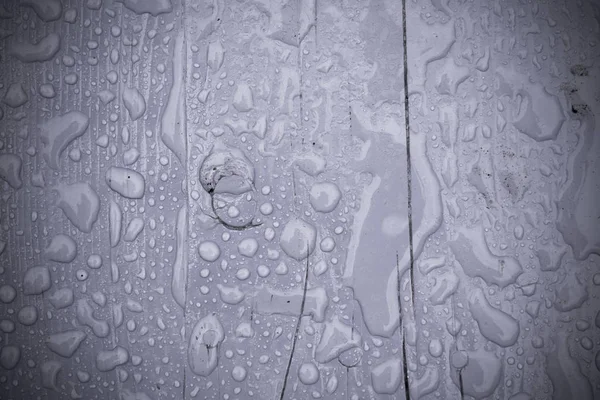 Gocce di pioggia su legno viola filtrato — Foto Stock