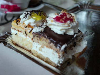 Taze kekler. Kırmızı ve sarı şeker, çikolata ve krema var..