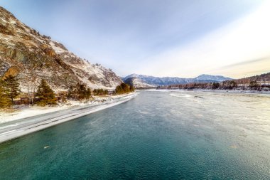 Karla kaplı dağlar ve dağ nehri manzarası