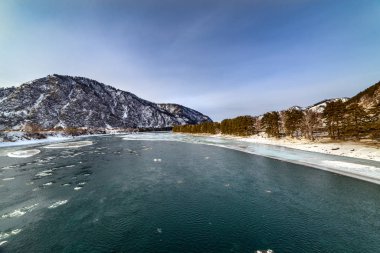 Karla kaplı dağlar ve dağ nehri manzarası